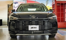 Mobil MG ZS hitam terparkir di dalam ruangan dengan boks telepon merah